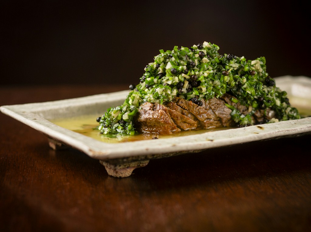 たっぷりの薬味ソースで肉の旨味が引き立てられた『羊のロースト ニラミントソース』