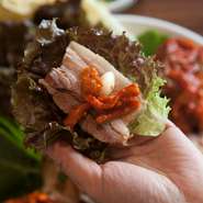 『ポッサム』とは茹でた豚肉を、キムチなどと一緒に野菜に巻いて食べる韓国料理。
肉はしっとり柔らかくてボリューム満点でクセがなくエゴマ半分とサンチェ一枚をまくのがお勧めの食べ方です。