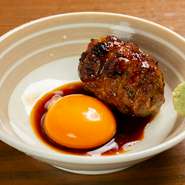 俵状のフォルムで登場する、ボリューム満点のつくね。卵かけごはん用の新鮮な卵黄と自家製醤油をたっぷり絡めれば、和風デミグラスソースのような濃厚な味わいに。