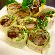 チキン竜田をサラダと金平牛蒡を巻いて仕上げに胡麻ソースをかけて、お出ししています。