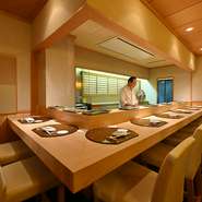 本格江戸前鮨の高級店でありつつ、夫婦経営ならではの温かなもてなしで、緊張感なく楽しめます。吉野檜の一枚板のカウンター、漆喰塗りの壁など、設えも落ち着いた佇まい。大人がゆっくり憩うのに格好の舞台です。