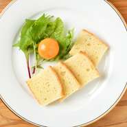 プルプルの食感がたまらない珍味、卵黄のピクルスと自家製のパンのコラボレーション。パンは後を引く美味しさ。ベビーリーフの彩りも添えられ、見た目にも美しい一皿です。