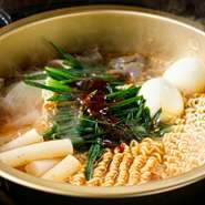 韓国ラーメン×トッポギでラッポギ。細縮れ麺ともちもちトッポギの異なる食感と、複数の調味料や薬味をブレンドした特製ヤンニョンの甘辛テイストがクセになる人気メニューです。