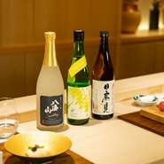 各地より集められた12～15種類の日本酒。提供しているお酒がなくなり次第、新たな日本酒を入れ替わりで用意。その時期飲み頃の日本酒と旬の幸を満喫できます。