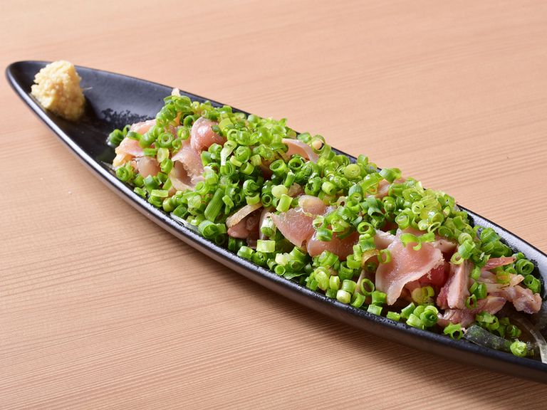 たっぷりの薬味に負けない、薩摩地鶏のもも肉のパンチのある旨みが口の中に広がる『薩摩地鶏のたたき』