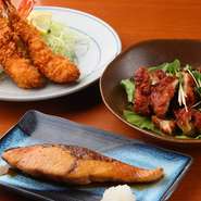 巨大天然エビをサクッと揚げた『エビフライ』、新鮮なブリの旨味が詰まった『ブリの照り焼き』は、老若男女に好評。調理スタッフがまかないで作ったメニュー『ピリ辛ソースのとり唐揚げ』はビールとの相性抜群！