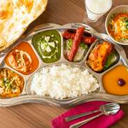 長さ50cmの大きなプレートに、ネパールのカレー3種が盛付けられた豪華なセットメニューです。シーカバブ、チキンティッカ、デザート付きで圧倒的ボリューム感。玄米飯は白飯やナンに変更可能で、おかわり自由です。