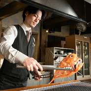 【北の海鮮炙り　ノアの箱舟】は、1人のスタッフが1卓に専属で付き目の前で豪快に焼き上げるスタイル。食べるスピードなどを考え、素材ごとに1番美味しいタイミングで提供してくれます。
