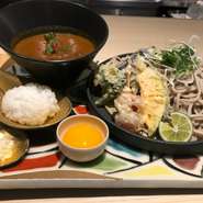 数種類のスパイスを使用したオリジナルのカレー出汁で楽しむ蕎麦。季節の天ぷらもトッピングしたボリュームある一品。〆ご飯や卵などもセットになっていて贅沢にお楽しみいただける。