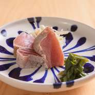 県内産の新鮮な鮪をブレンドした醤油に漬けて寝かせ、藁焼きで仕上げたもの。5段階の工程で時間をかけて丁寧につくっています。島ニラを使ったカラシ醤油で食すと更に旨みが増し、お酒にも合う一品です。