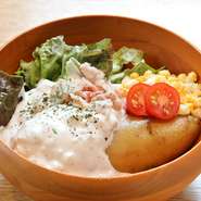 皮付きのメークインがまるごと1個入ったオリジナルの一品。食べる時は、ほくほくのメークインをお好みで潰しながら、焼きべーコン、トマト、ゆで玉子のみじん切りと一緒に、自家製タルタルソースを絡ませてどうぞ。