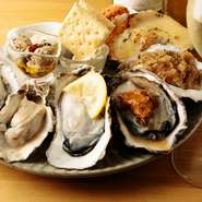 生牡蠣・焼牡蠣・蒸牡蠣の盛り合わせ。なにを食べようか迷ったらまずオーダーしてほしい一品。自慢のオイスター料理9種類を贅沢に味わえます。さまざまな調理法で仕上げられた牡蠣は、美味の極み。