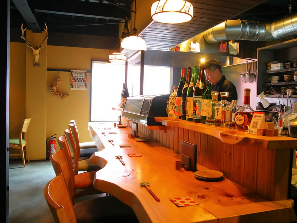 重厚感のある一枚板のカウンターが設えられた、居心地のよい店内
