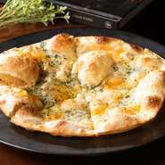 専門店から仕入れるチーズが4種乗った薄焼きピザ。ブルーチーズやモッツァレラなど、チーズの「旬」にこだわり、その時期においしいものが使われています。パリパリと軽く食べられるのでおつまみとしても。