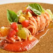 その日最も品質の良いフレッシュトマトを使用したパスタ。爽やかな酸味のトマトの上に、甘みの強いフルーツトマトやカラートマト、自家製バジルを添えることで、トマトの酸味と甘み際立つシンプルな逸品です。