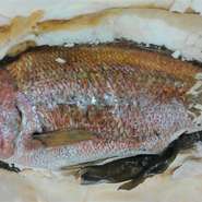 鯛を一尾丸ごと塩で包み、ゆっくりとオーブンで焼き上げた一品。旨味を中に閉じ込めた鯛の身は柔らかくふっくらとして最高の焼き魚に仕上がります。
お祝いの席などにいかがですか？