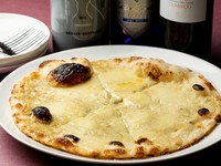 はちみつや生クリームを用い、ゴルゴンゾーラチーズを中心に4種のチーズがまろやかな風味のパリパリピッツァ。陶器製の瓶がオシャレなフランス産ワイン「アール・ドゥ・ヴィーヴル」のお供にもピッタリ。