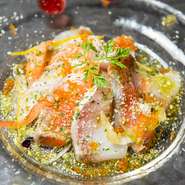 カルパッチョにはその日仕入れた鮮魚を2～3種類使用。画像はサーモンとカンパチ。白ワインビネガーを使ったさっぱり味のドレッシングと、たっぷりのパルミジャーノチーズ、魚介の見事なハーモニーを楽しめます。
