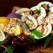 専門店ならではの豊富な貝は常時15～25種類。馴染みのあるものから珍しいものまであり、一番おいしい状態で食べられるようにスタッフが目の前で焼いてくれるので後は味わうだけ！　大人気のメニューです。