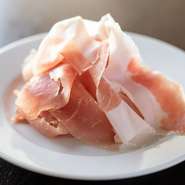 注文後にイタリア・パルマ産の原木からスライサーで切り出される『生ハム』は、塩分とバージンオリーブオイルの甘みが溶け合う深い味わい。一緒に頼んだ『ピザ』や『ポテトサラダ』へのトッピングもオススメです。