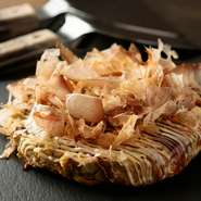 お好み焼きと言ったらこれ！定番中の定番です。野菜がたっぷり入った生地に、カリカリとした香ばしい豚肉が加われば、それだけで大満足の一品です。かつお節をたっぷりかけて召し上がれ！