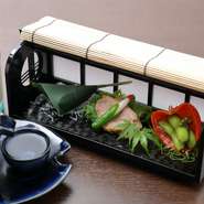 目でも舌でも季節の恵みを味わえる一皿。夏には「鯵の笹巻寿司」、長芋とシシトウと梅肉を朝顔のつぼみに見立てた「朝顔長芋」を乗せた「合鴨のカレー煮」、ほおずきを敷いた「枝豆の山椒風味」などが並びます。


