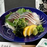 一本釣りで釣り上げすぐに首を折って血抜きをするため、いつの間にか［首折れサバ］と呼ばれるようになりました。その身は歯ごたえが強く甘いのです。当店は、いけすに泳がせているのでプリプリの首折れが一番人気