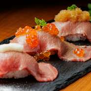 質にこだわり抜いた新鮮な黒毛和牛と、肉との相性を考慮して特別にブレンドした米を使った『黒毛和牛　炙りにぎり三種盛』は、熱烈なファンも多い当店自慢の一品。みぞれおろしといくら、自家製泡塩を添えてどうぞ。