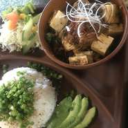 しっかりした味わいと硬さの島豆腐は、地元の老舗山城とうふより仕入、オリジナルのピリ辛ブレンド肉ソースを絡めて白髪ねぎと糸唐辛子をトッピング、フレッシュサラダやアボカドを盛付。胡麻ネギ飯添え・澄し汁付。