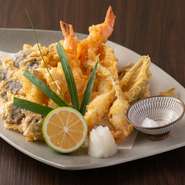長浜市場で仕入れるとびきりの旬魚介、ふっくら美味しい海老、糸島産の季節野菜など、6～8種をカラリと揚げて盛り合わせに。素材の持ち味と食感を満喫でき、食べ飽きない美味しさ！　他に『穴子の天ぷら』も人気。