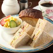 香ばしさが魅力の胚芽パンを使ったミックスサンドです。玉子、ハム、胡瓜、トマトと具材をたっぷり挟んだサンドイッチは、軽くトーストした胚芽パンの味わい深さが楽しめます。コーヒーと一緒にどうぞ。