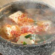 牛肉ベースのスープにアサリ、青唐辛子、豆腐、ねぎ、玉ねぎなどが入ったチゲです。アサリの旨みが加わった奥深い味わいのピリ辛スープに、卵を落としてマイルドに。辛いのがお好みの方は辛さアップも可能です。