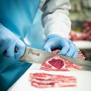 お肉は生産段階から一切冷凍することなく、厳重な温度管理のもと28日間以上熟成させます。その後、当店の職人が長年培った経験により、匂い・味・色・触感で品質を吟味し部位の特性に合わせて手切りして提供します。