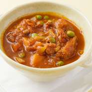 トロトロになるまで柔らかく煮た牛すじと数種類の野菜のトマト煮込みです。チリペッパーたっぷりで一度食べるとやみつきになる味です。