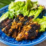 生のターメリック（ウコン）を使った漬けダレに一晩寝かした鶏もも肉一枚をグリルしたタイ南部地方の料理です。