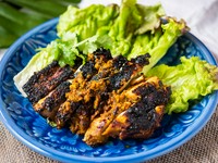 生のターメリック（ウコン）を使った漬けダレに一晩寝かした鶏もも肉一枚をグリルしたタイ南部地方の料理です。