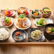 旬の食材をたっぷり使った日替わりおかず9種に、季節の雑穀をブレンドしたごはんとこだわりだしの味噌汁がついたお膳です。一品ずつの盛り付けで、一皿ごとのおいしさを味わえます。美しい彩りも楽しんで。