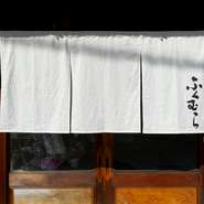 メイン通りからは少しそれた場所に位置する【彩佳肴　ふくむら】。隠れ家風の佇まいで、どこか非日常感も味わえます。木の温もりを感じさせてくれるレトロモダンな空間で、ゆったりくつろげます。