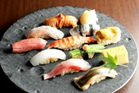 江戸前の握りに合わせ、三種類の赤酢をブレンドしたシャリ。粘り気が少なく、鮨にしたときネタとともにほろっと崩れる食感を楽しめます。赤味噌やあらだしなど、季節の味が楽しめるお椀と巻物が付いた贅沢な一品。