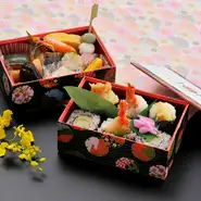 一口サイズの食べやすい天むすのお弁当。旬の食材を使った焼八寸や煮物も入っておりコンパクトサイズながらボリュームのある一品です。