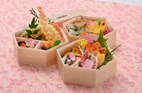 コンパクトな三段のお弁当箱。天ぷらや八寸、お造りなどのおかずがぎっしり。こだわりの一つである "ご飯"は味も彩りも豊かな二種類を盛り込みました。品数もボリュームもたっぷり。おすすめです。