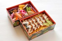二段重ねの豪華なお弁当。一段にはふっくら香ばしく焼き上げたうなぎに秘伝のタレを絡めたうな重を。もう一段には季節の焼物と煮物を彩りよく詰め合わせました。