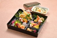 八寸、和え物、お造り、焚き合せ、天麩羅、フルーツに季節の御飯が付いたスタンダートな料理をお持ち帰りが出来る容器でお届けします。