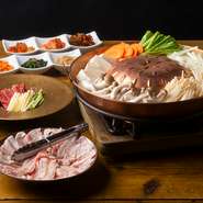 一日煮込み旨味を存分に引き出した豚骨スープに、国産野菜や牛もつを贅沢に入れ込んでいます。また、鍋の上で豚バラ肉をさっと焼くことで香ばしさをUPさせたお鍋です。　