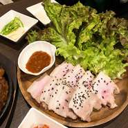 熟成豚バラ肉をお好みの薬味とともにサンチュに包んで