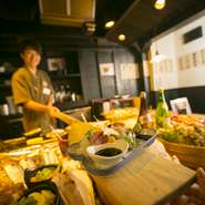 焼き師が櫂(かい)を使って料理をお届け！