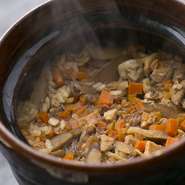 米屋から直接仕入れた【ヒカリ新世紀米】を用いた土鍋ごはん。炊き立てのにおいと粒立ちの良さは食欲がかきたてられます。ひねどりを使用することによって鳥の旨味が凝縮されています。
