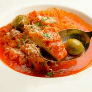 トリッパ（牛の胃袋・ハチノス）を自家製トマトソースとトスカーナ産のグリーンオリーブで煮込み、仕上げにパルミジャーノレッジャーノをたっぷりとかけた一品。濃厚な味わいで赤ワインとの相性もバッチリ。