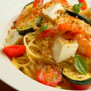 香ばしくソテーしたエビとクリーミーなイタリア産のモッツアレラチーズのハーモニーがたまらないオイルパスタ。季節の野菜と自家製アンチョビパン粉がアクセントを添えています。