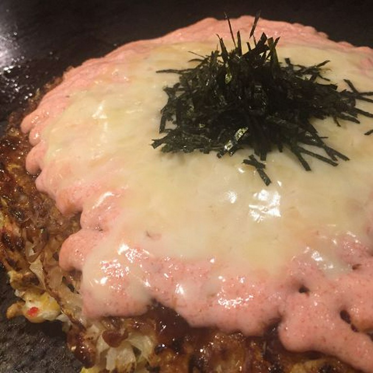 お好み焼きの上にたっぷりの明太ソースと、とろけるチーズ